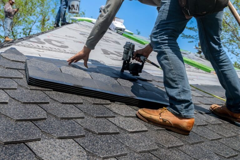 Roofer installing shingles on a new roof